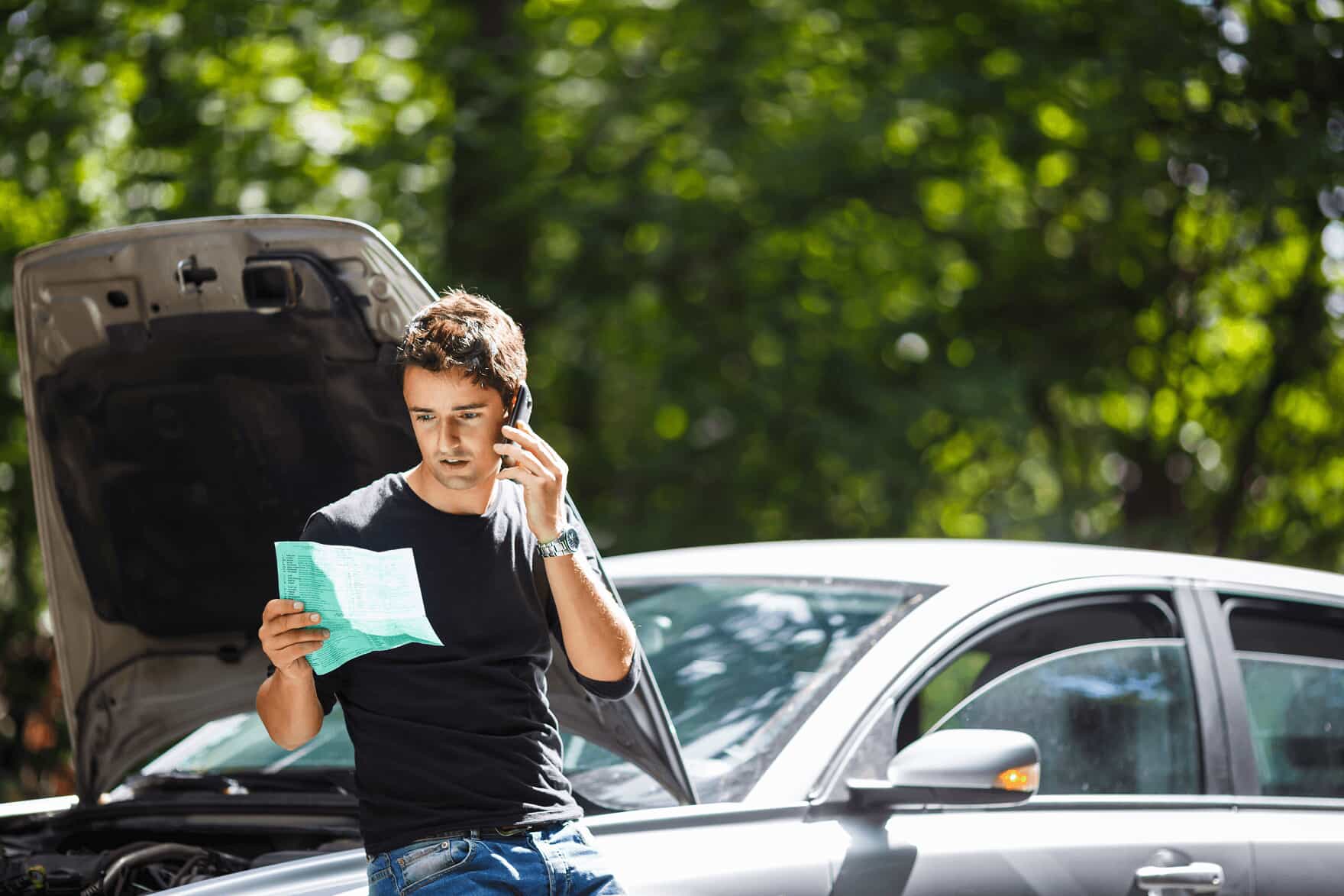 A young man on the phone after a car accident