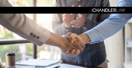 two business owners shaking hands in front of a lawyer